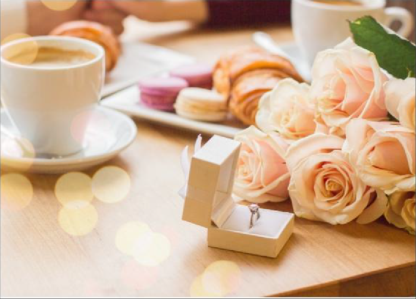 テーブルの上に置かれた花と婚約指輪